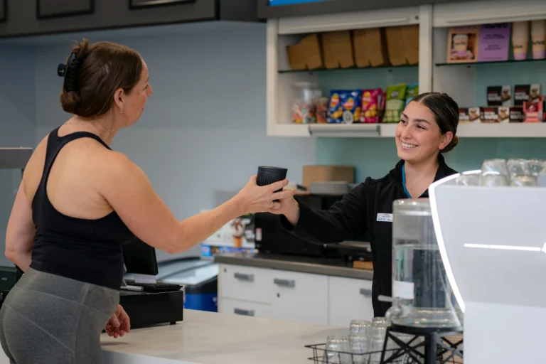 Café attendant passing coffee to patron